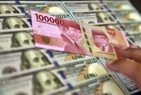 Petugas jasa penukaran valuta asing memeriksa lembaran mata uang rupiah dan dollar AS di Jakarta, Senin (2/7). Mata uang rupiah di pasar spot exchange berada di level Rp14.375 per dolar AS atau terdepresiasi 50 poin atau 0,35 persen dibandingkan perdagangan sebelumnya yang berada pada nilai Rp14.325. ANTARA FOTO/Puspa Perwitasari/kye/18