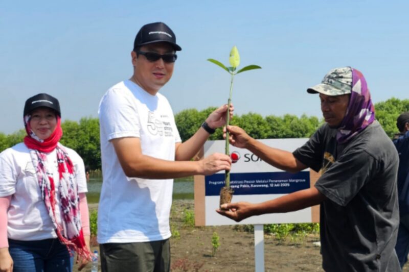 Naoki Inoue serahkan bibit mangrove kepada warga Tanjungpakis, simbol komitmen pelestarian lingkungan. (Dok. Sompo Insurance)